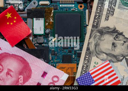 A technology conflict, competition concept with the American and Chinese flags on top of a semiconductor circuit board. Stock Photo