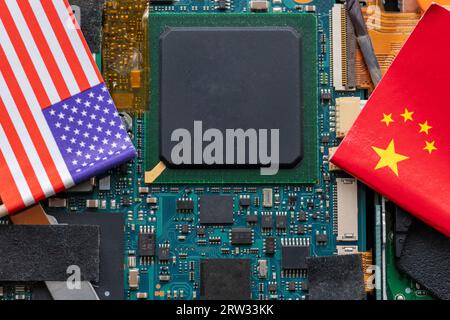 A technology conflict, competition concept with the American and Chinese flags on top of a semiconductor circuit board. Stock Photo