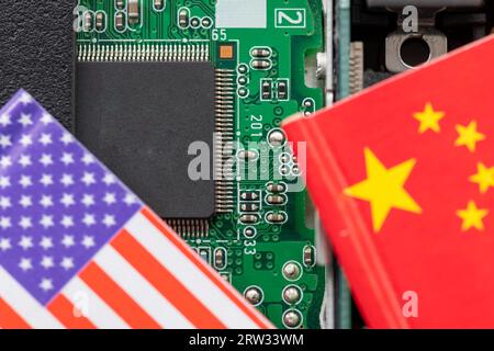A technology conflict, competition concept with the American and Chinese flags on top of a semiconductor circuit board. Stock Photo