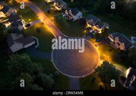 Cul de sac street dead end at night and private residential houses in rural suburban sprawl area in Rochester, New York. Upscale suburban homes with Stock Photo