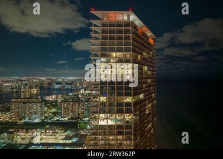 Residential high-rise skyscraper at night with view on Sunny Isles Beach city in Florida, USA. Housing development in modern american urban area Stock Photo