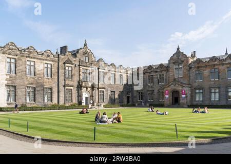 Students sitting on the grass in St Salvator's Quadrangle, Uniiversity of St Andrews, Fife, Scotland, UK Stock Photo