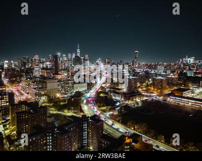 Night panoramic shot of modern metropolis with illuminated skyscrapers and busy highway. New York City, USA Stock Photo