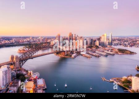 Pink sunrise over city of Sydney major architecture landmarks on shores of Sydney harbour from elevation. Stock Photo