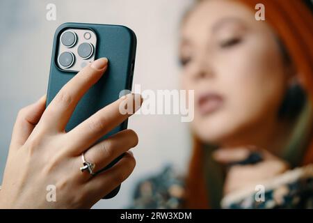 Attractive woman posing takes selfie on iPhone 13 pro. Stock Photo