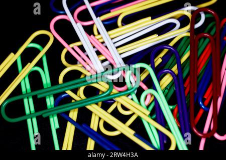 Multicolored Large Paper Clips isolated on black Stock Photo