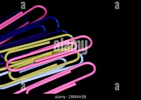 Multicolored Large Paper Clips isolated on black Stock Photo