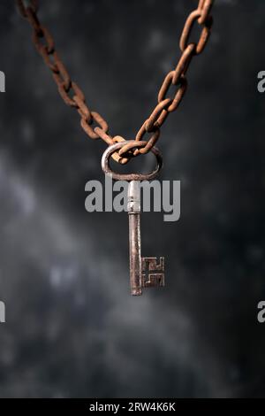 Rusty Key Chain Old big key hanging from a rusty chain Stock Photo - Alamy
