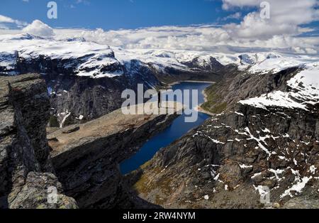 Hiker enjoying the view from Trolltunga in Norway after a long trek Stock Photo