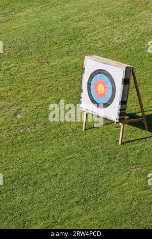 Archery round paper face field target on a stand on a green field with freshly cut grass Stock Photo