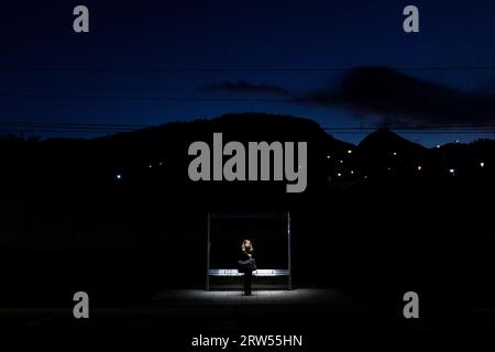 Santiago, Metropolitana, Chile. 16th Sep, 2023. A woman waits for public transport at a bus stop in Santiago, Chile, at dusk. (Credit Image: © Matias Basualdo/ZUMA Press Wire) EDITORIAL USAGE ONLY! Not for Commercial USAGE! Stock Photo