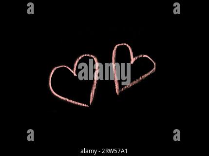 Sign and symbol of love, relationships, romance, heart, object drawn with colored crayon on a black background, close-up. Stock Photo