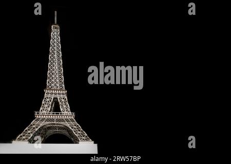 Eiffel Tower object toy shape made of wood on a black background copy space. Stock Photo