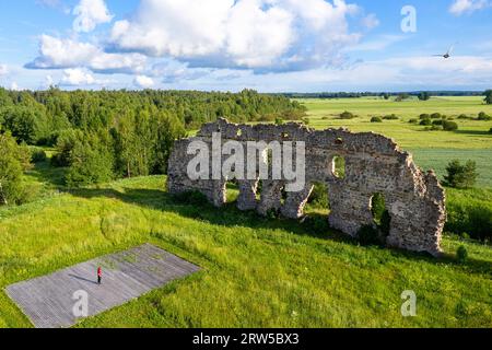 Aerial view of a tourist looking at the ruins of a Laiuse Castle on a beautiful sunny summer day in Estonia Stock Photo