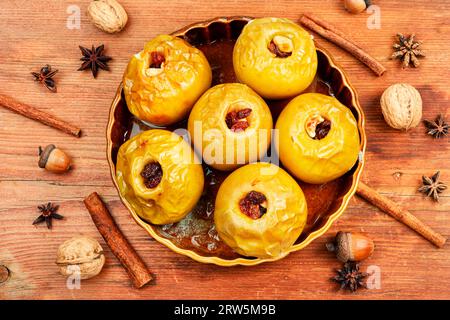 Homemade baked apples stuffed with nuts and raisins. Autumn dessert on a wooden old table. Top view. Stock Photo