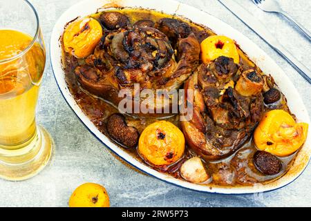 Roast pork knuckle or shank baked with stewed cabbage in baking tray with beer. Stock Photo