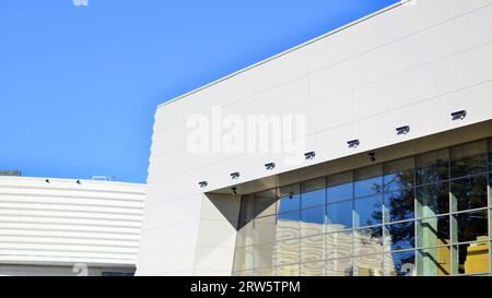 Minimalist photo of an exterior of a modern tin building with big glass showcases. Stock Photo