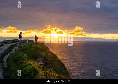 Cliffs of Moher, cliffside hiker, The Burren, County Clare, Ireland, United Kingdom Stock Photo