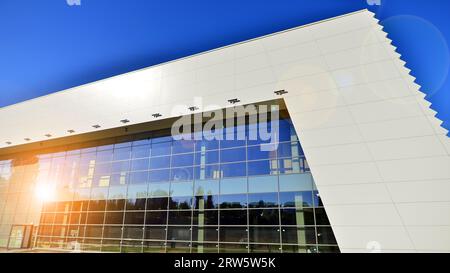 Minimalist photo of an exterior of a modern tin building with big glass showcases. Stock Photo