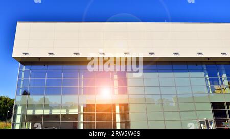 Minimalist photo of an exterior of a modern tin building with big glass showcases. Stock Photo