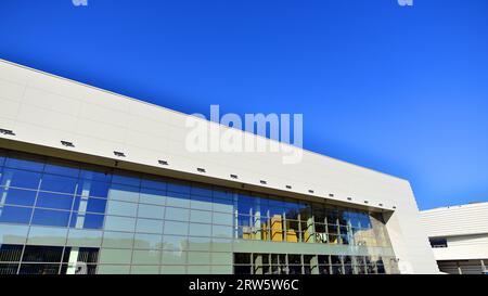 Minimalist photo of an exterior of a modern tin building with big glass showcases. Stock Photo