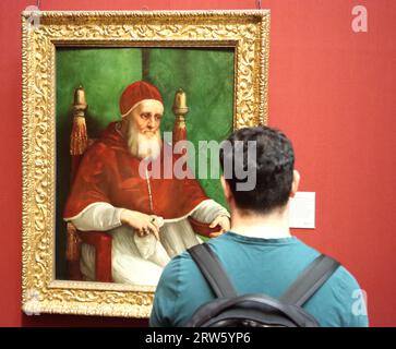 A visitor studying the painting Portrait of Pope Julius II by Italian Renaissance painter Raphael at the National Gallery, London, UK Stock Photo