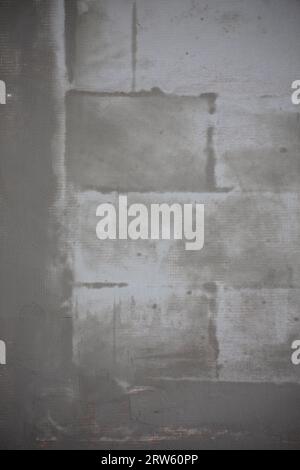 Fresh gray plaster on the wall of the house, leveling material of the facade Stock Photo