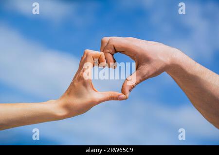 Girl hand in heart form love blue sky Stock Photo - Alamy