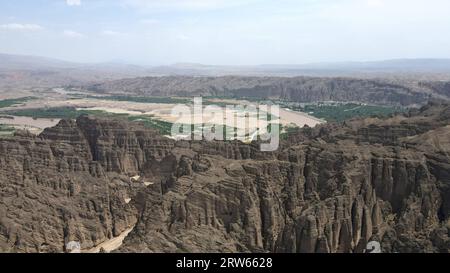 (230917) -- LANZHOU, Sept. 17, 2023 (Xinhua) -- This aerial photo taken on July 11, 2023 shows the Longwan Village and Yellow River Stone Forest in Jingtai County of Baiyin City, northwest China's Gansu Province. The Yellow River, originating from the Bayan Har Mountains, meanders thousands of miles in Gansu. On both sides of the river, ancient cities, towns and villages formed and prospered, and became important guardians and inheritors of the Yellow River culture. In recent years, Gansu Province has continuously strengthened the preservation and revitalization of ancient cities, towns an Stock Photo