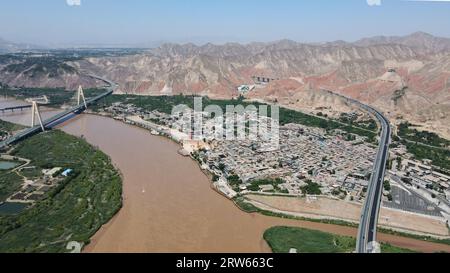 (230917) -- LANZHOU, Sept. 17, 2023 (Xinhua) -- This aerial photo taken on July 9, 2023 shows a view of Hekou ancient town in Lanzhou, northwest China's Gansu Province. The Yellow River, originating from the Bayan Har Mountains, meanders thousands of miles in Gansu. On both sides of the river, ancient cities, towns and villages formed and prospered, and became important guardians and inheritors of the Yellow River culture. In recent years, Gansu Province has continuously strengthened the preservation and revitalization of ancient cities, towns and villages along the Yellow River, protecting Stock Photo