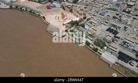 (230917) -- LANZHOU, Sept. 17, 2023 (Xinhua) -- This aerial photo taken on July 9, 2023 shows a view of Hekou ancient town in Lanzhou, northwest China's Gansu Province. The Yellow River, originating from the Bayan Har Mountains, meanders thousands of miles in Gansu. On both sides of the river, ancient cities, towns and villages formed and prospered, and became important guardians and inheritors of the Yellow River culture. In recent years, Gansu Province has continuously strengthened the preservation and revitalization of ancient cities, towns and villages along the Yellow River, protecting Stock Photo