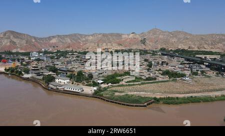 (230917) -- LANZHOU, Sept. 17, 2023 (Xinhua) -- This aerial photo taken on July 9, 2023 shows a view of Hekou ancient town in Lanzhou, northwest China's Gansu Province. The Yellow River, originating from the Bayan Har Mountains, meanders thousands of miles in Gansu. On both sides of the river, ancient cities, towns and villages formed and prospered, and became important guardians and inheritors of the Yellow River culture. In recent years, Gansu Province has continuously strengthened the preservation and revitalization of ancient cities, towns and villages along the Yellow River, protecting Stock Photo