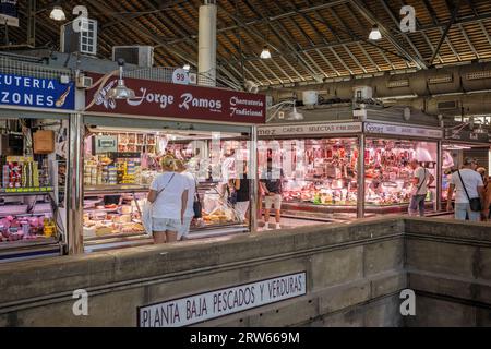 Meat stalls and shoppers inside the Mercado de Asbastos in Alicante, Spain on 29 August 2023 Stock Photo
