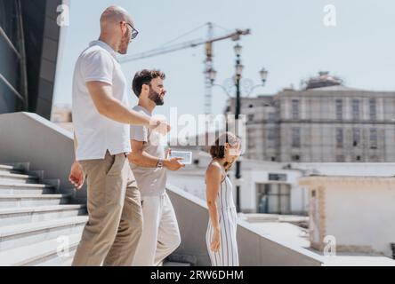 A professional team outdoors collaborating on marketing strategies, analyzing reports and training for success. Stock Photo