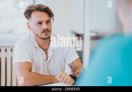 Experienced Doctor Analyzing Diagnostic Test Results with Young Male Patient Stock Photo