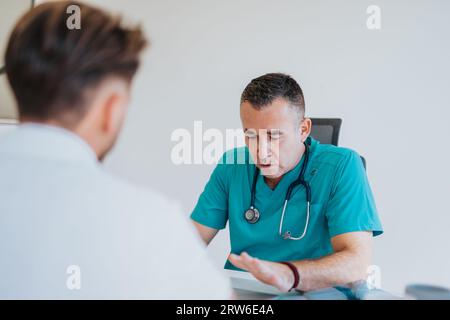 Experienced Doctor Analyzing Test Results: Advice and Diagnosis for Young Male Patient Stock Photo