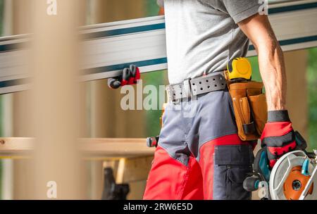 Construction Contractor Worker with Tools in His Hands Moving Around Close Up Photo. Stock Photo
