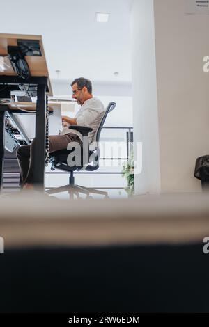 Confident business people analyzing reports in a creative office. Diverse team using tech for data analysis and market research. Efficient entrepreneu Stock Photo