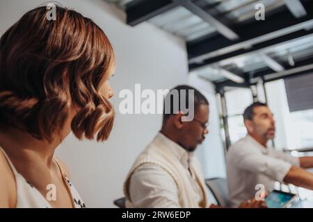 A diverse group of professionals collaborate and make decisions in a modern, multicultural meeting room. This productive business meeting exudes succe Stock Photo