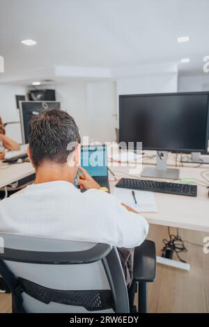 Diverse, efficient team in a modern office analyzing reports, planning, and using technology to create a successful business. Stock Photo