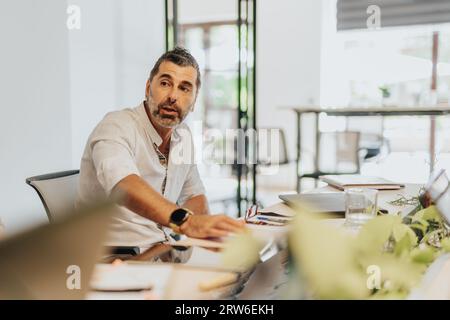 A diverse business team discussing strategies and analyzing statistics in a modern office. Stock Photo
