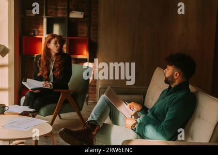 Two young businesspeople talking business while working remotely at coffee bar Stock Photo