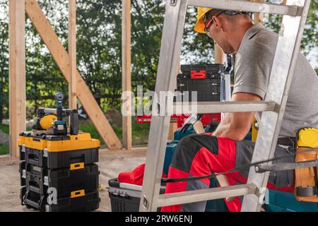 Construction Worker Taking Short Lunch Break. Construction Site and His Tools Boxes. Stock Photo