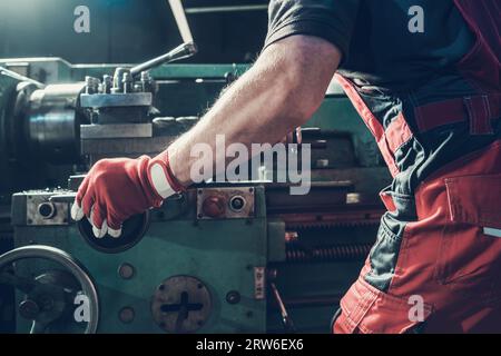 Caucasian Metalworking Worker in His 40s Operating Lathe Machine. Industrial Theme. Stock Photo