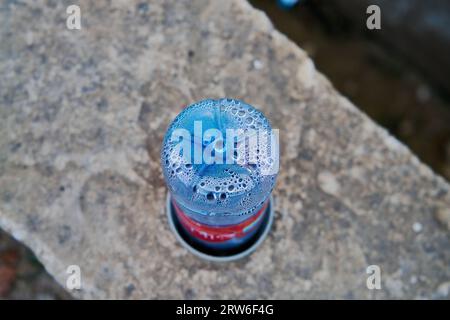 An empty plastic bottle of water in the street Stock Photo