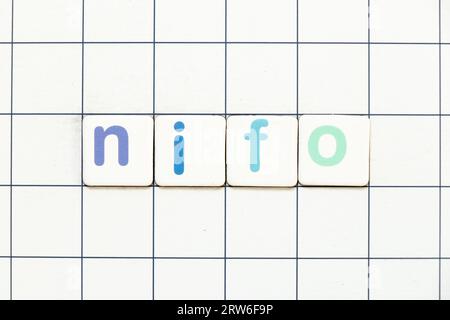 Colorful tile letter in word NIFO (abbreviation of next in first out) on white grid background Stock Photo