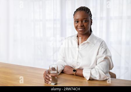Cheerful young african woman nutritionist posing at workplace Stock Photo
