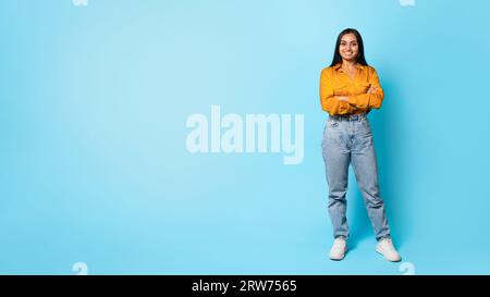 Cheerful Middle Eastern Woman Standing Over Blue Background, Full Length Stock Photo