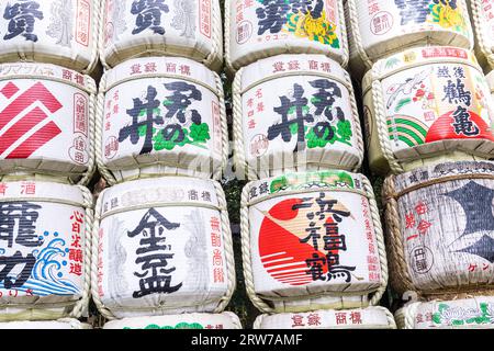 Stacks of colorful Japanese Sake barrels donated by distillers at the south entrance to the Meiji Jingu located inside a 170 acres forest, in Shibuya, Tokyo, Japan. The Shinto shrine is dedicated to the spirits of Emperor Meiji and his wife, Empress Shoken. Stock Photo