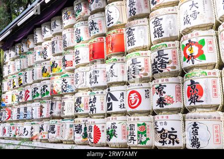 Stacks of colorful Japanese Sake barrels donated by distillers at the south entrance to the Meiji Jingu located inside a 170 acres forest, in Shibuya, Tokyo, Japan. The Shinto shrine is dedicated to the spirits of Emperor Meiji and his wife, Empress Shoken. Stock Photo